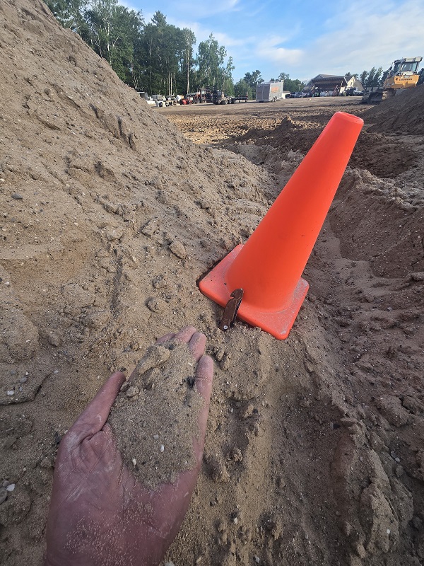 pile of sand ready to be delivered with cone for size reference